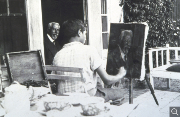 Reynold Arnould peignant un portrait de Victorien Lelong dans sa propriété de La Saulaie à Offranville, vers 1932. Photographie. Collection particulière