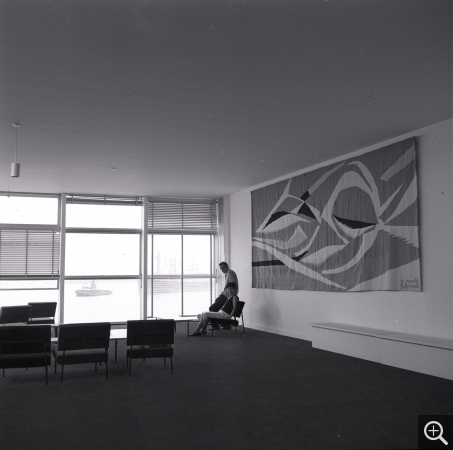 Marthe et Reynold Arnould dans le bar-club devant la tapisserie La Vague de Reynold Arnould, 1961