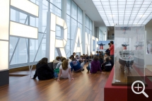 Visite commentée devant la maquette et les lettres lumineuses du pont du paquebot. © MuMa Le Havre / Renaud Dessade